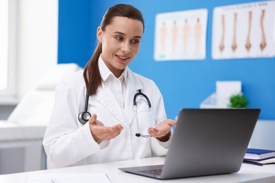 Photo of Doctor having online consultation via laptop in clinic