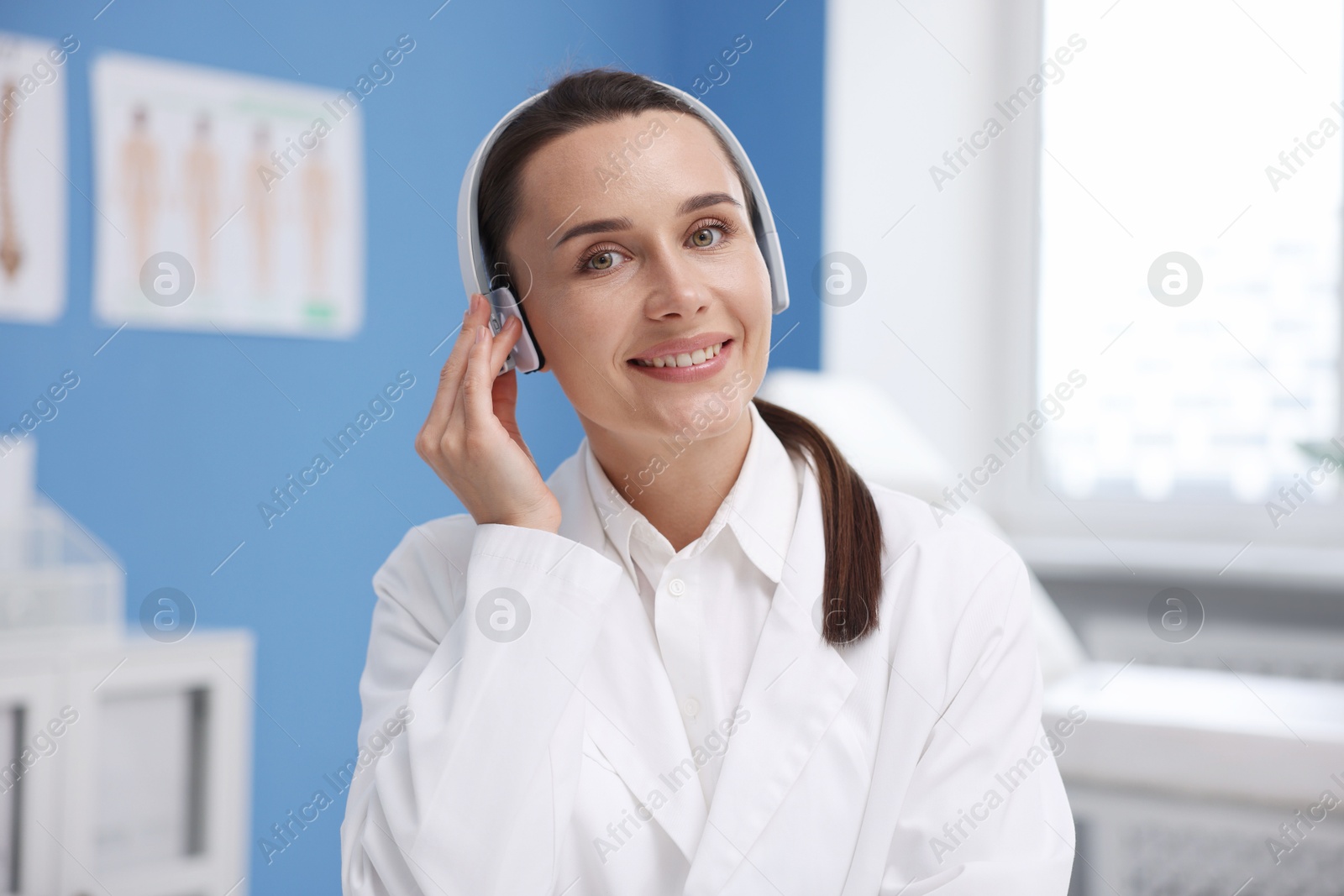 Doctor with headphones having online consultation in clinic Photo of Doctor with headphones having online consultation in clinic