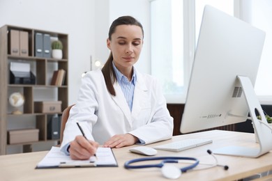 Photo of Doctor having online consultation via computer in clinic