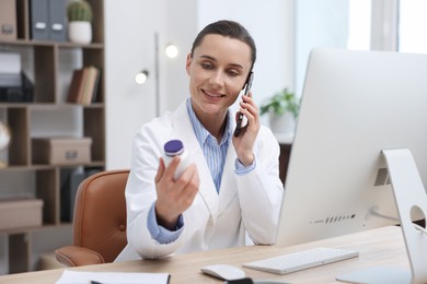 Photo of Doctor with smartphone and pills having online consultation in clinic