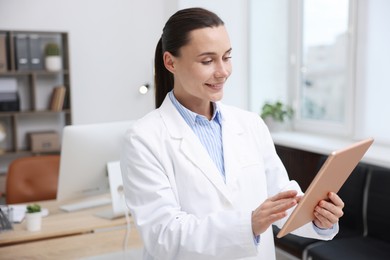 Photo of Doctor using tablet in clinic, space for text. Online medical consultation