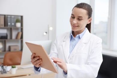 Photo of Doctor using tablet in clinic. Online medical consultation