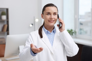 Photo of Doctor with smartphone having online consultation in clinic