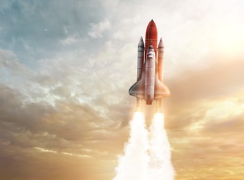 Image of Modern space rocket in beautiful cloudy sky