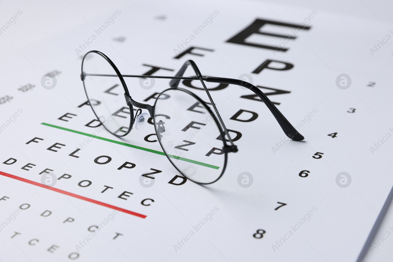 Glasses on vision test chart, closeup view Photo of Glasses on vision test chart, closeup view