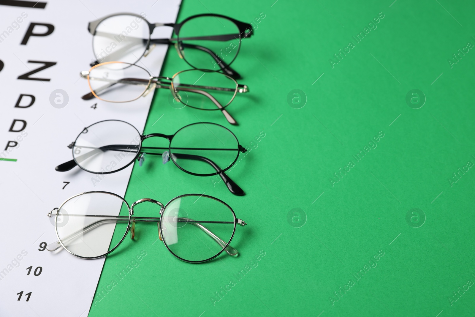 Vision test chart and glasses on green background, closeup. Space for text Photo of Vision test chart and glasses on green background, closeup. Space for text