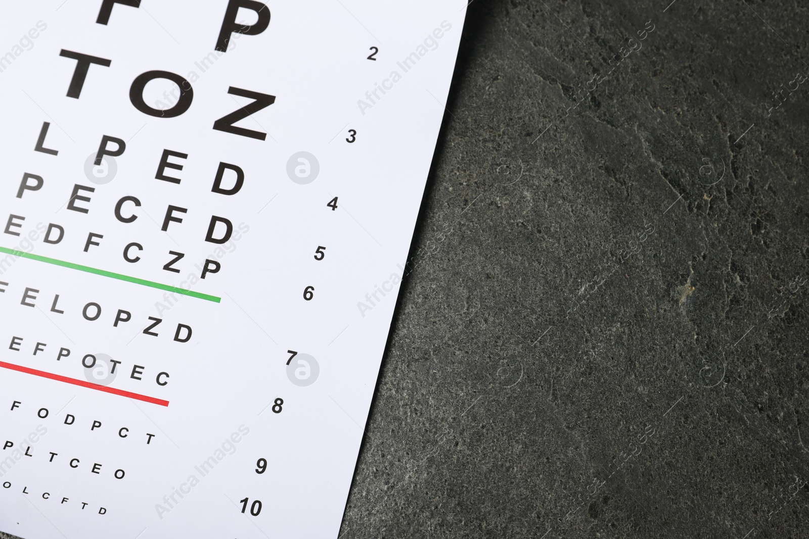 Vision test chart on grey table, top view. Space for text Photo of Vision test chart on grey table, top view. Space for text