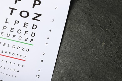 Photo of Vision test chart on grey table, top view. Space for text