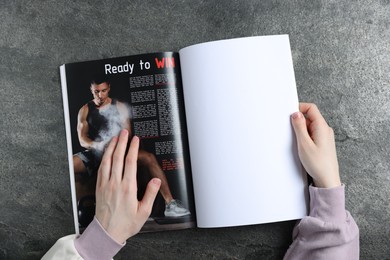 Photo of Woman reading magazine at grey table, top view. Mockup for design
