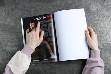 Photo of Woman reading magazine at grey table, top view. Mockup for design