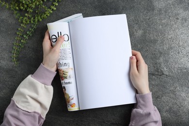 Photo of Woman reading magazine at grey table, top view. Mockup for design