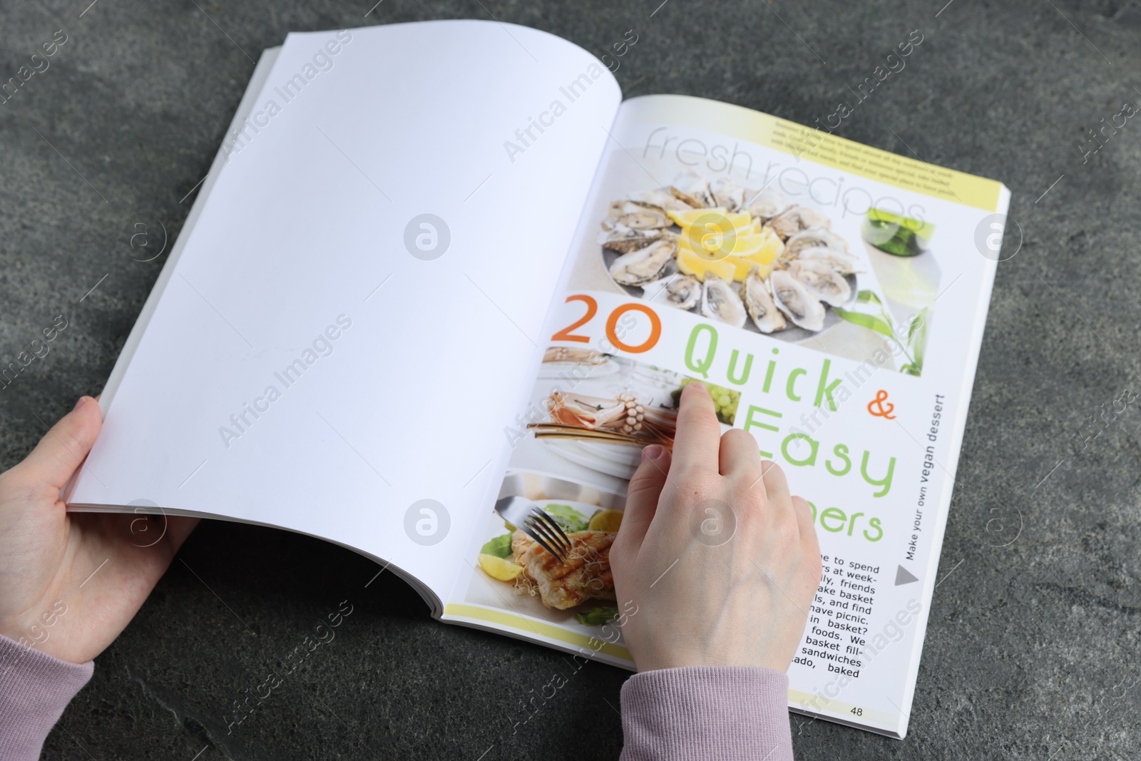 Woman reading magazine at grey table, closeup. Mockup for design Photo of Woman reading magazine at grey table, closeup. Mockup for design