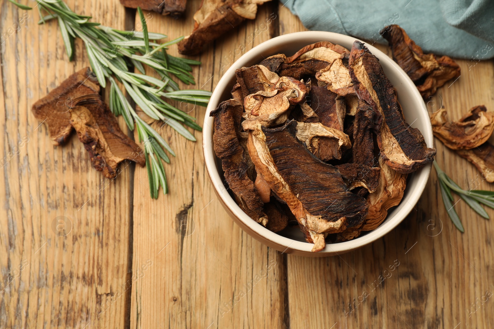 Dried chanterelle mushrooms with rosemary on wooden table, flat lay Photo of Dried chanterelle mushrooms with rosemary on wooden table, flat lay