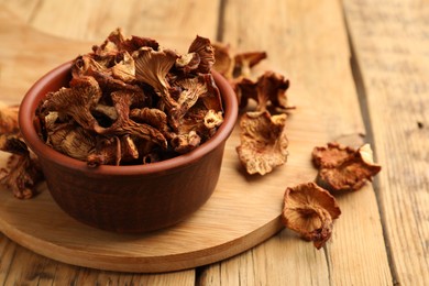 Photo of Dried chanterelle mushrooms on wooden table, closeup