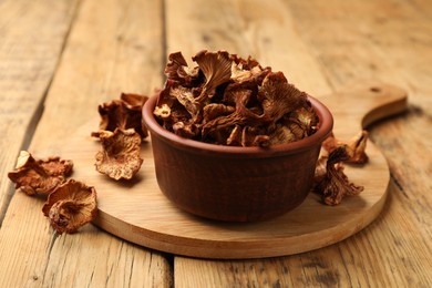 Photo of Dried chanterelle mushrooms on wooden table, closeup