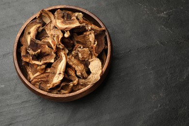 Photo of Dried chanterelle mushrooms on wooden table, top view. Space for text