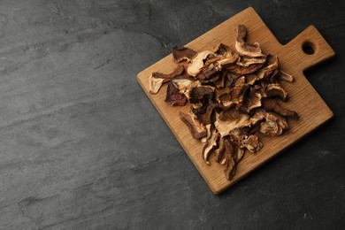 Photo of Dried chanterelle mushrooms on wooden table, top view. Space for text