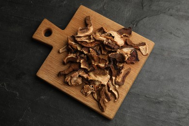 Photo of Dried chanterelle mushrooms on wooden table, top view