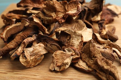 Photo of Dried chanterelle mushrooms on wooden board, closeup