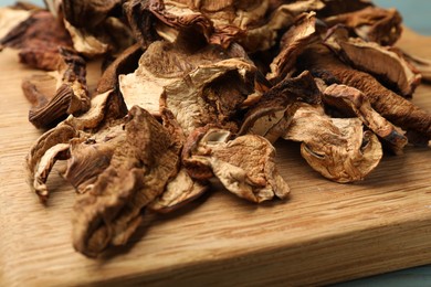 Photo of Dried chanterelle mushrooms on wooden board, closeup
