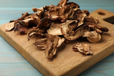 Photo of Dried chanterelle mushrooms on blue wooden table, closeup