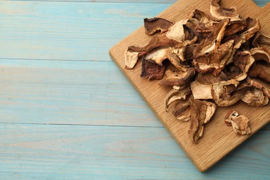 Photo of Dried chanterelle mushrooms on blue wooden table, top view. Space for text