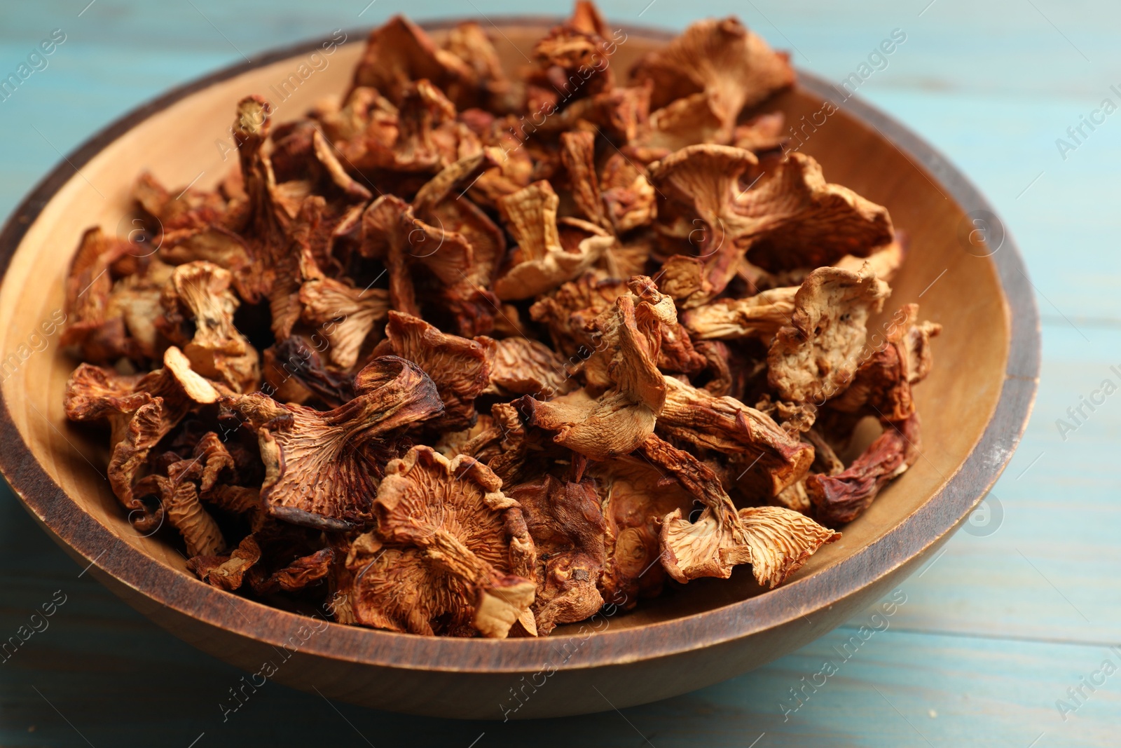 Photo of Dried chanterelle mushrooms on wooden table, closeup