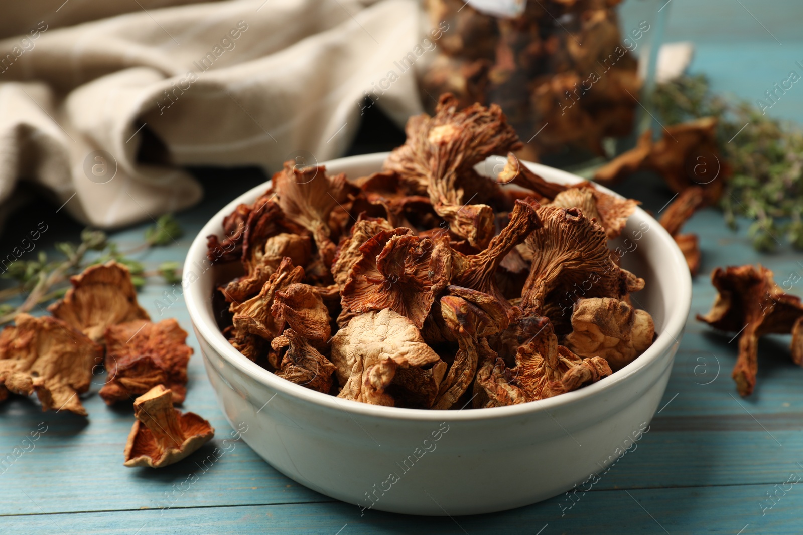 Photo of Dried chanterelle mushrooms on blue wooden table, closeup