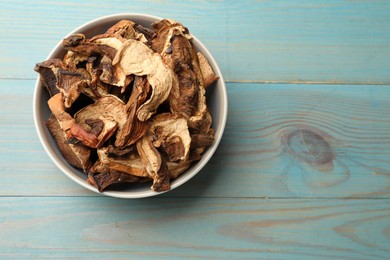 Photo of Dried chanterelle mushrooms on blue wooden table, top view. Space for text