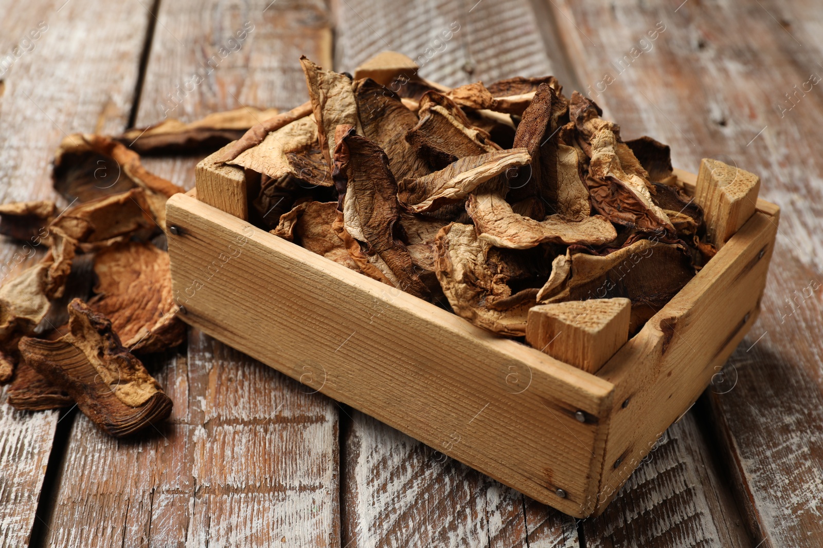 Photo of Dried chanterelle mushrooms on wooden table, closeup