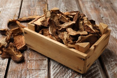Photo of Dried chanterelle mushrooms on wooden table, closeup