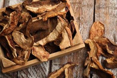 Photo of Dried chanterelle mushrooms on wooden table, flat lay