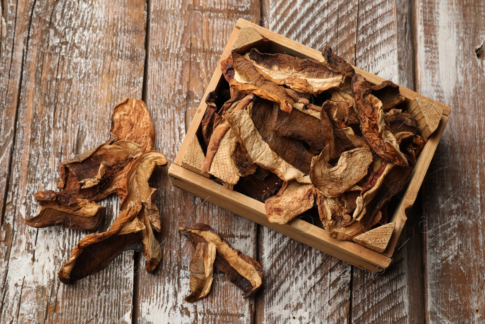 Photo of Dried chanterelle mushrooms on wooden table, flat lay