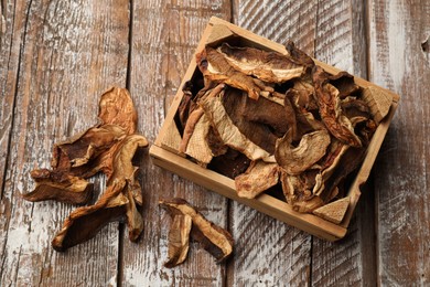 Photo of Dried chanterelle mushrooms on wooden table, flat lay