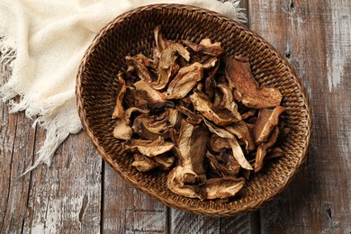 Photo of Dried chanterelle mushrooms on wooden table, top view
