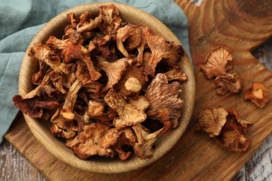 Photo of Dried chanterelle mushrooms on wooden table, flat lay