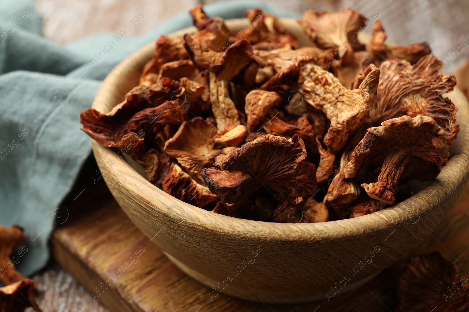 Photo of Dried chanterelle mushrooms on wooden table, closeup