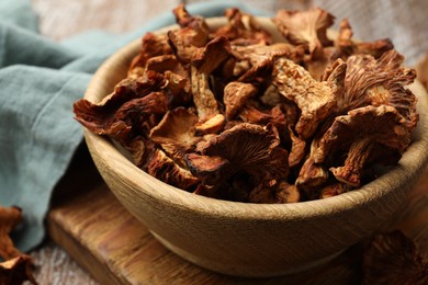 Photo of Dried chanterelle mushrooms on wooden table, closeup