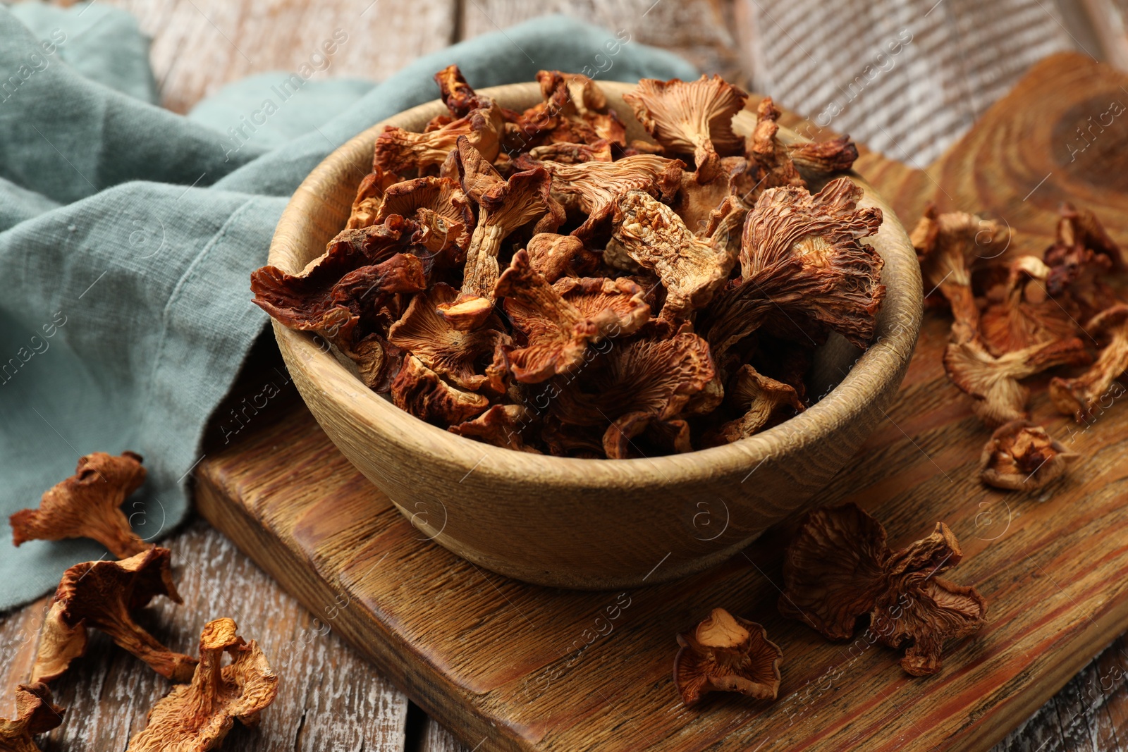 Photo of Dried chanterelle mushrooms on wooden table, closeup