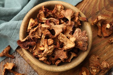 Photo of Dried chanterelle mushrooms on wooden table, flat lay