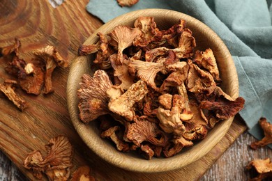 Photo of Dried chanterelle mushrooms on wooden table, flat lay