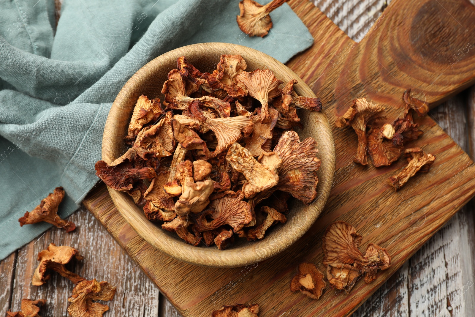 Photo of Dried chanterelle mushrooms on wooden table, flat lay