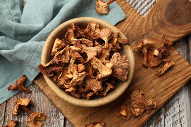 Photo of Dried chanterelle mushrooms on wooden table, flat lay