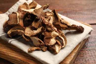 Photo of Dried chanterelle mushrooms on wooden table, closeup
