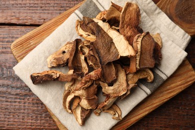 Photo of Dried chanterelle mushrooms on wooden table, top view