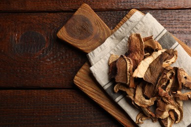 Photo of Dried chanterelle mushrooms on wooden table, top view. Space for text