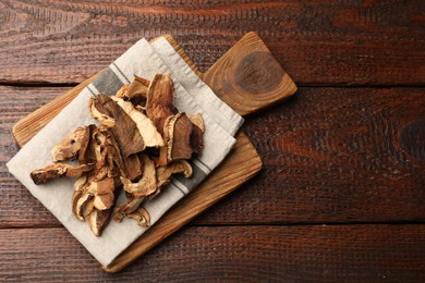 Photo of Dried chanterelle mushrooms on wooden table, top view. Space for text