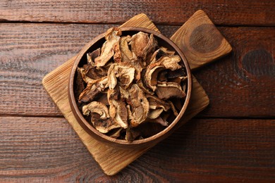 Photo of Dried chanterelle mushrooms on wooden table, top view