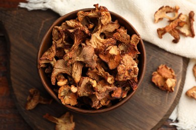 Photo of Dried chanterelle mushrooms on wooden table, flat lay