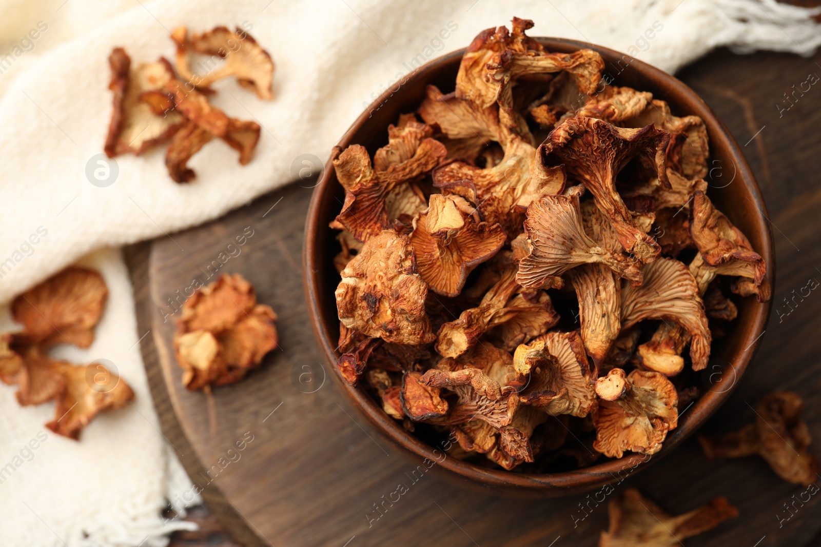 Photo of Dried chanterelle mushrooms on wooden table, flat lay